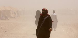 Eine Frau aus Falludsche in der staubigen Wüste
