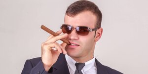 Geschäftsmann mit Sonnenbrille und Zigarre