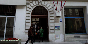 Der Eingang zur Berggasse 19 in Wien: Graue Mauern, eine Toreinfahrt, in die Menschen hineinlaufen