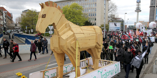 Ein hölzernes Pferd und viele Demonstranten