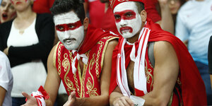 Zwei rot-weiß geschmickte türkische Fans schauen betrübt drein
