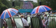 Mehrere Menschen sitzen im Park und feiern den 90. Geburtstag der britischen Königin