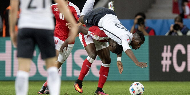 Der nach unten gebäugte Embolo hat Pogba im Huckepackstil auf den Schultern.