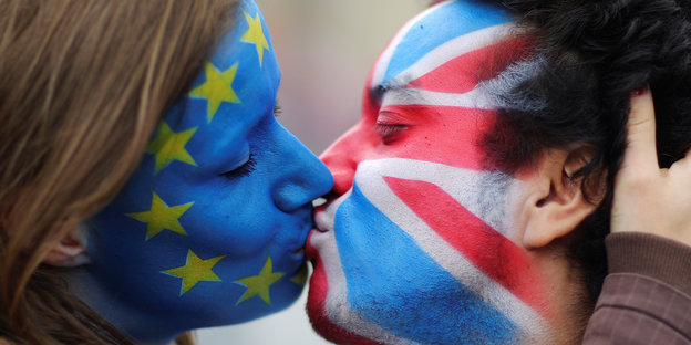 Eine Frau und ein Mann küssen sich. Sie hat die Europa-Fahne aufs Gesicht gemalt, er den Union Jack.