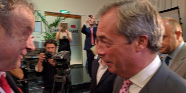 Nigel Farage und ein anderer Mann im Vordergrund, im Hintergrund Pressefotografen Nigel Farage und ein anderer Mann im Vordergrund, im Hintergrund Pressefotografen