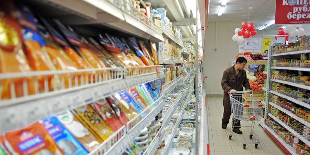 Mann mit Einkaufswagen in einem russischen Supermarkt