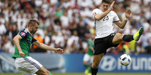 Mario Gomez (r.) will einen von McAuley geschlagenen Ball blocken