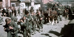Soldaten der deutschen Wehrmacht marschieren durch Vilkija, Litauen.