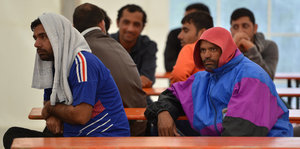 Zwei Männer sitzten in einer Flüchtlingsunterkunft und gucken ziemlich deprimiert.