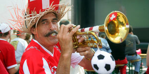 Ein Schweizer Fußballfan bläst in seine Trompete