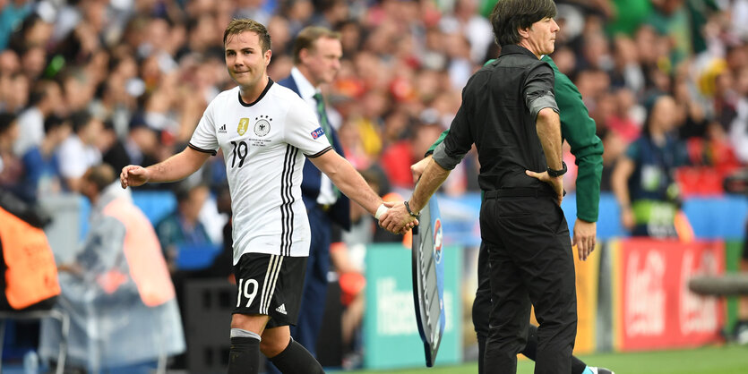 Jögi Löw klatscht Mario Götze bei dessen Auswechslung ab. Löws Blick geht auf das Spielfeld, Götze schaut in die andere Richtung