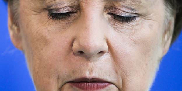 Angela Merkel mit gesenktem Blick