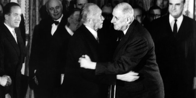 Ein schwarz-weiß Bild: Konrad Adenauer und Charles de Gaulle umarmen sich