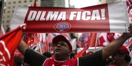 Ein Unterstützer von Dilma Rousseff hält ein Banner mit der Aufschrift "Dilma Fica!" in die Höhe. Das heißt "Dilma bleibt!".