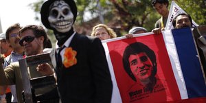 Menschen tragen ein Plakat mit dem Gesicht Victor Jaras