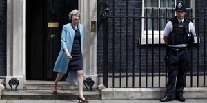 Die britische Innenministerin Theresa May verlässt 10 Downing Street, neben der Tür steht ein Bobby