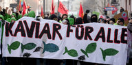 Menschen tragen ein Plakat auf dem "Kaviar für alle" geschrieben steht
