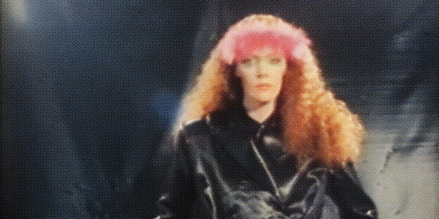Ein stark gerastertes Foto einer Frau mit langen roten lockigen Haaren in 80er-Ästhetik