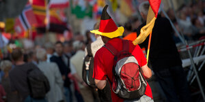 Ein Pegida-Demonstrant mit Accessoires in Deutschlandfarben