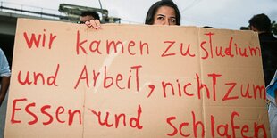 Schild: "Wir kamen zum Studieren und Arbeiten, nicht zum Essen und Schlafen."