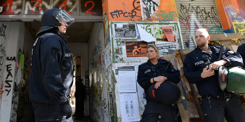 Polizisten stehen vor einem Hauseingang