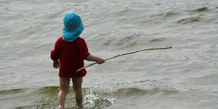 Ein Kind läuft am 03.04.2016 im Strandbad Wannsee in Berlin bei frühlingshaften Temperaturen ins Wasser