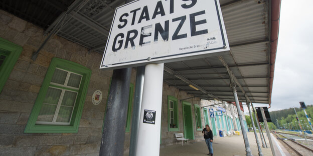 Auf einem Schild an einem Bahnhof steht das Wort Staatsgrenze