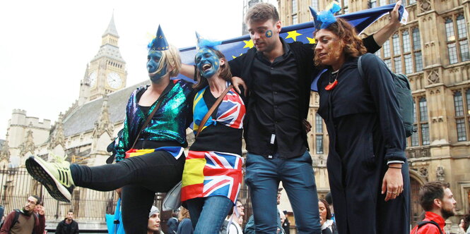 Vier junge Menschen haben sich teilweise die EU-Flagge ins Gesicht gemalt, stehen hintereinander, einer hält die EU-Flagge hinter ihnen