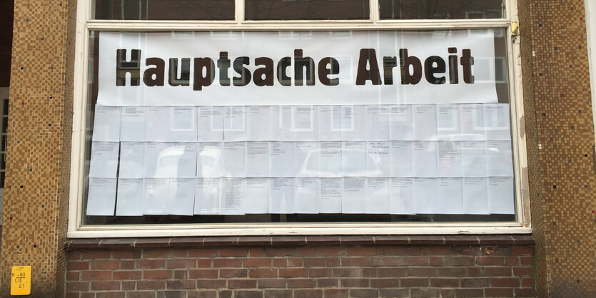 Fenster mit Papier zugeklebt, darauf in großer Schrift: „Hauptsache Arbeit“