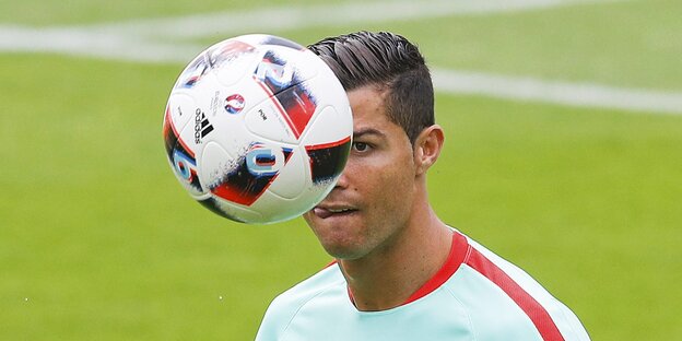 Ein Ball verdeckt die Hälfte von Ronaldos Gesicht