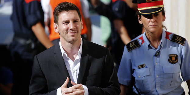 Lionel Messi wird von einer Polizistin ins Gericht begleitet