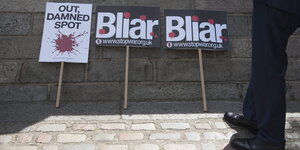 Plakate mit der Aufschrift Blair und Out, damned spot lehnen an einer Wand
