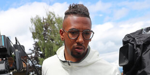 Jerome Boateng mit Brille vor Kameras nach einer Pressekonferenz