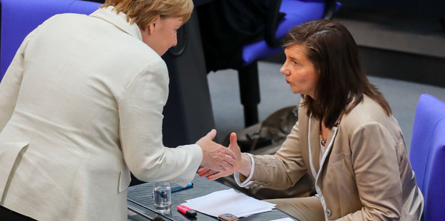 Zwei Frauen diskutieren miteinander. Es sind Merkel und Göring-Eckhardt