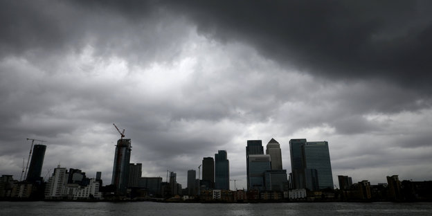Skyline des Londoner Finanzdistrikts, darüber düstere Wolken