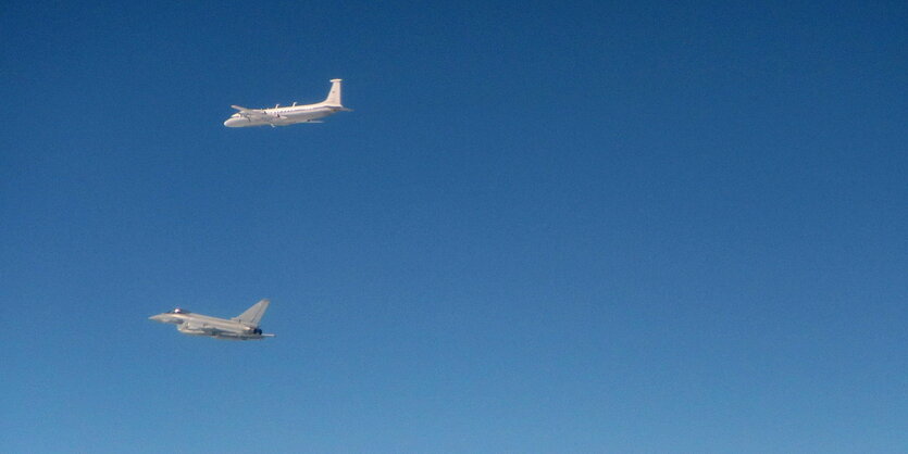 Ein Flugzeug der Royal Air Force und ein russisches Kampfflugzeug vor blauem Himmel