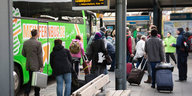 Busreisende mit Koffern gehen zum Eingang eines Busses im Zenralen Omnibusbahnhof von Berlin