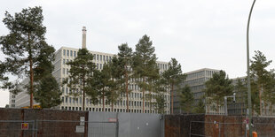 Gebäude hinter Mauer und Bäumen