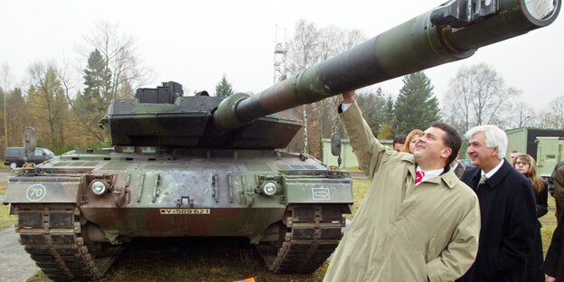 Sigmar Gabriel hält die Hand an das Kanonenrohr eines Panzers