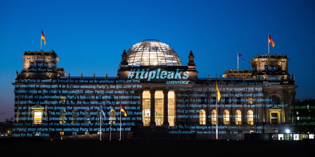 Das Reichstagsgebäude bei Nacht, es werden verschiedene Textausschnitte auf das Gebäude projiziert