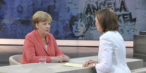 Zwei Frauen sitzen einander gegenüber. Es sind Angela Merkel und die Journalistin Bettina Schausten