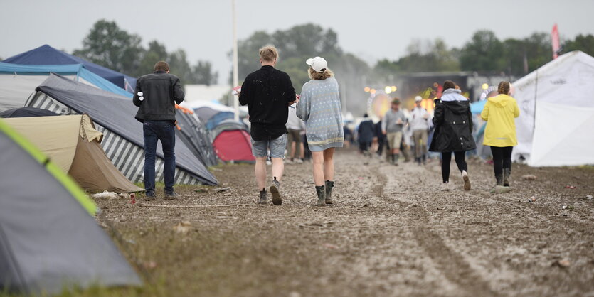 Ein matschiger Campingplatz, wenige Menschen sind zu sehen