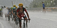 Radfahrer Richie Porte (vorne) und seine Kollegen fahren im strömenden Regen den Berg hinauf