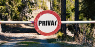 Ein "Privat"-Schild über einem Waldweg