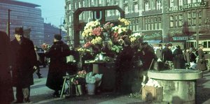 An der U-Bahnstation Potsdamer Platz verkaufen Menschen Blumen, andere laufen vorbei