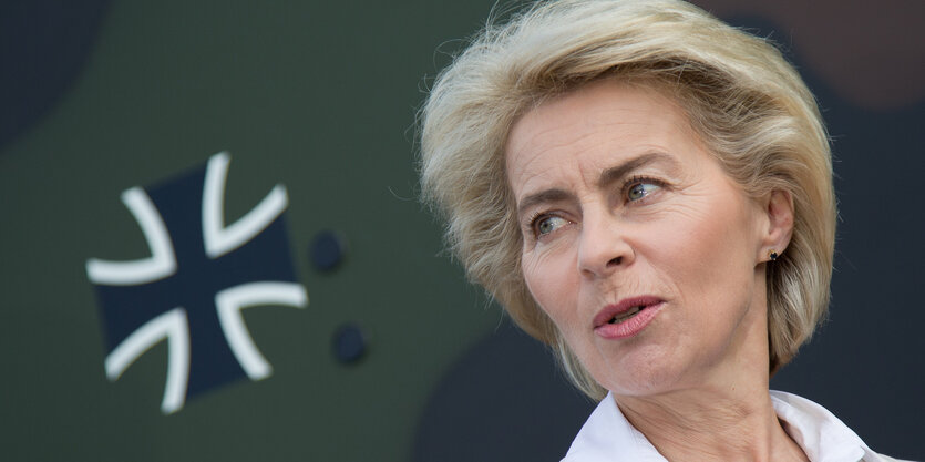 Ursula von der Leyen neben einem Fahrzeug mit einem Hoheitszeichen der Bundeswehr.