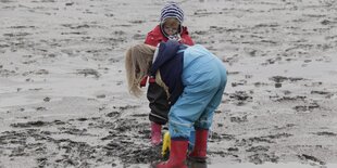 Zwei Kinder spielen im Schlamm