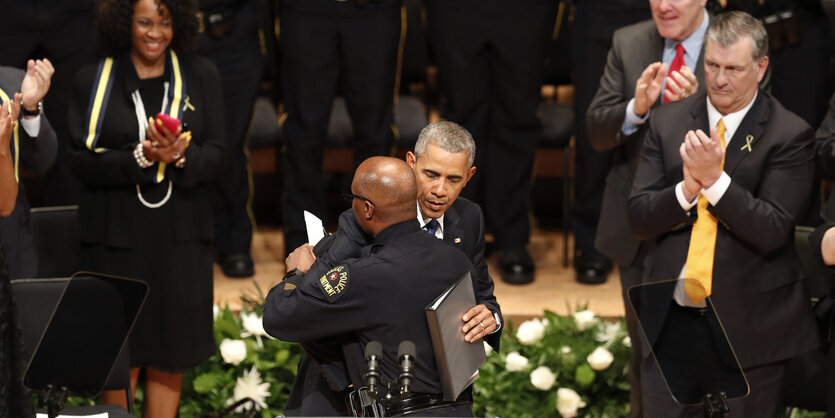 Obama und der Polizeichef umarmen sich, im Hintergrund klatschen Menschen