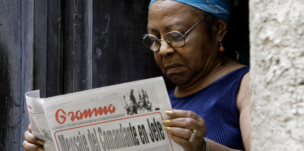 Eine Schwarze Frau liest eine Zeitung