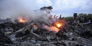 Brennende und rauchende Trümmerteile eines Flugzeugs